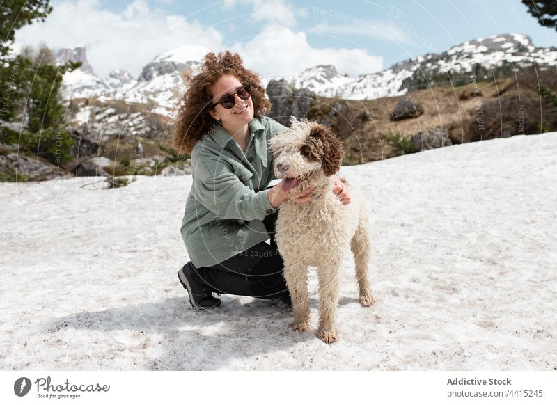 Woman playing with dog on snowy meadow in highlands woman winter mountain having fun playful owner female dolomite alps italy pet nature happy joy animal