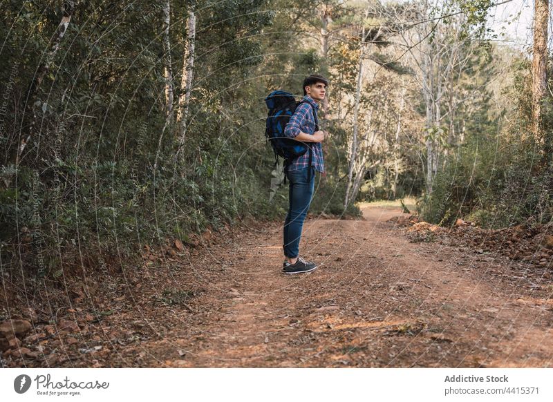 Male hiker with backpack in woods man trekking forest sand road travel traveler male nature explore freedom adventure wanderlust backpacker environment explorer