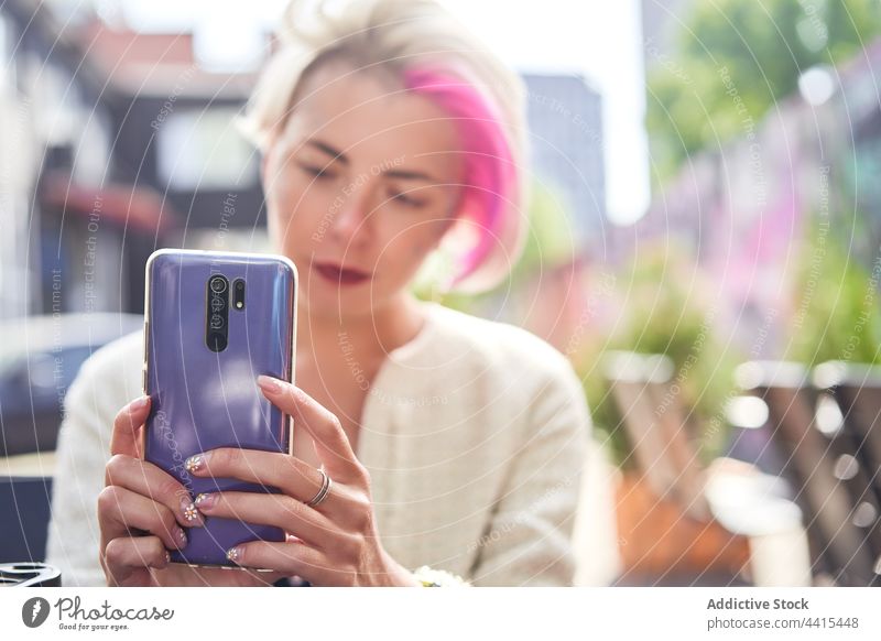 Alternative woman messaging on smartphone in street message city informal subculture style social media cellphone using female browsing mobile focus surfing