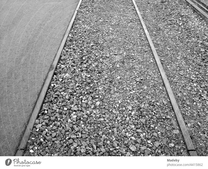 Track bed filled up with ballast between old rails at the inland port in Offenbach am Main in Hesse, photographed in traditional black and white track Railroad