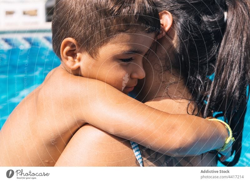 Young woman with son in swimming pool tired summer water garden together vacation mother boy parent motherhood poolside kid childhood activity resort daytime