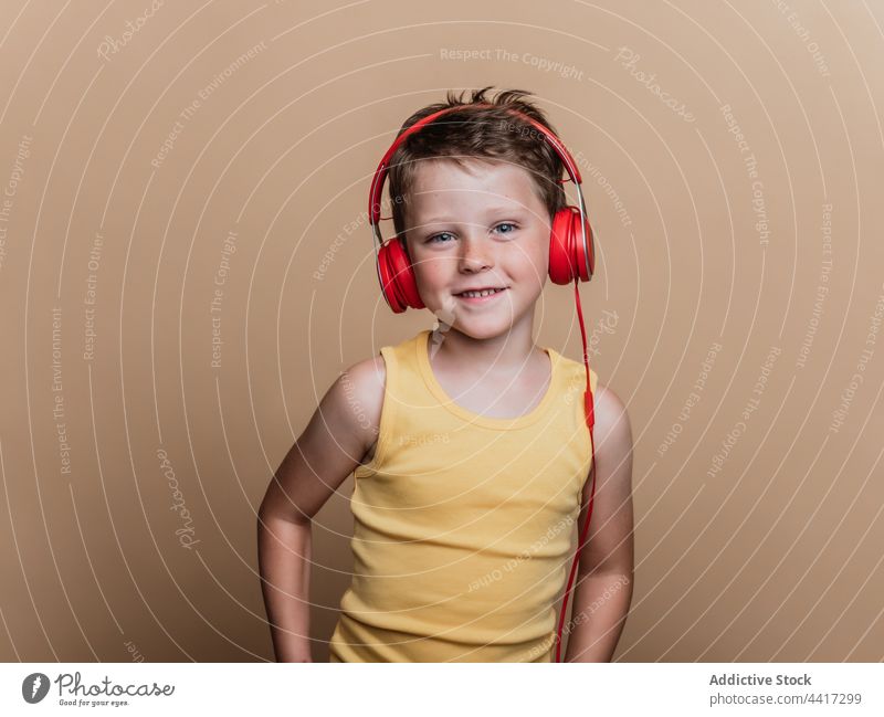 Cheerful child listening to music in headphones song enjoy preteen boy entertain studio kid device gadget sound style cool amusement talent audio childhood