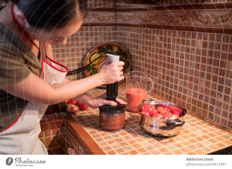 woman blending tomatoes in blender vegetable process prepare cook kitchen marinara female sauce home ingredient food culinary housewife recipe meal vegetarian