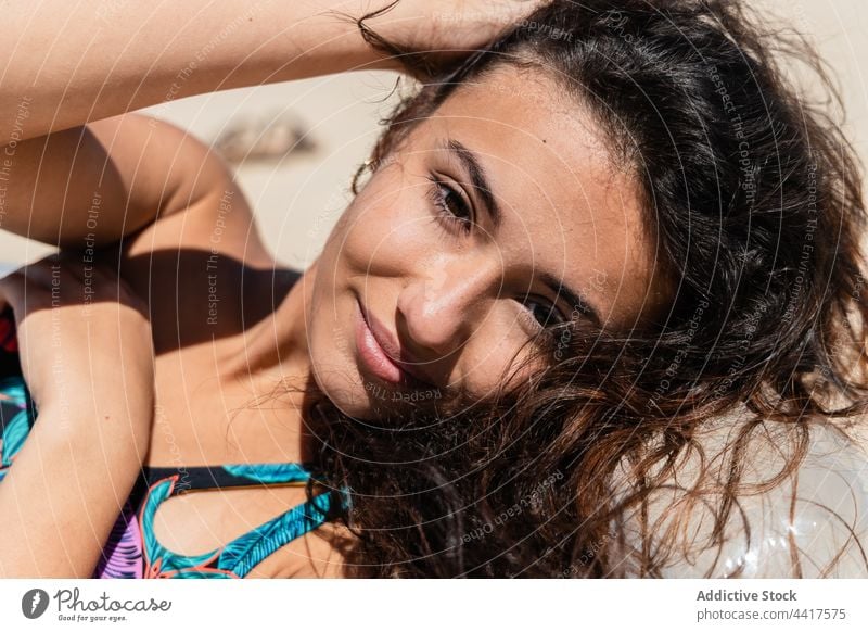 Cheerful woman sunbathing on inflatable mattress on beach suntan summer vacation swimsuit holiday female relax lying carefree pleasure sunlight summertime enjoy