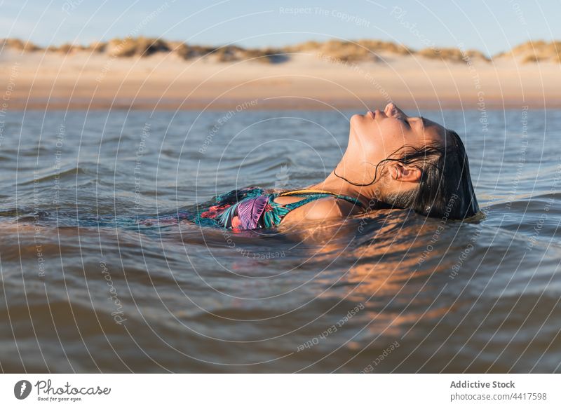 Charming woman swimming in sea in sunset water wet hair charming summer tranquil carefree female calm serene enjoy idyllic quiet paradise dreamy recreation