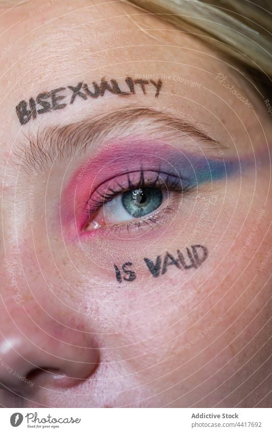 Young lesbian woman with bright makeup looking at camera lgbtq homosexual bisexual pride flag tolerance eye inscription bisexuality is valid gay liberty symbol