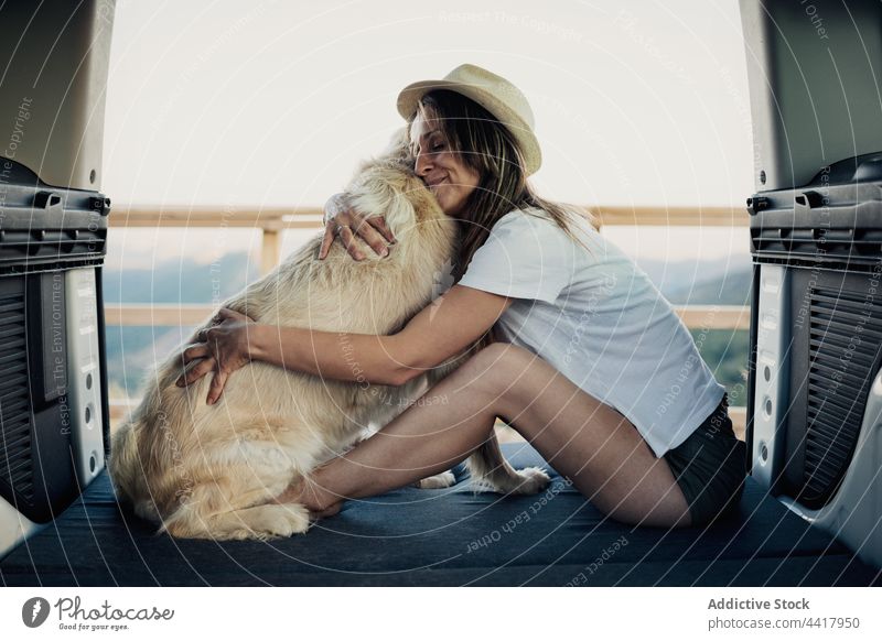 Female owner embracing dog in camper woman road trip bed together hug travel nature female golden retriever loyal embrace obedient training trick command animal