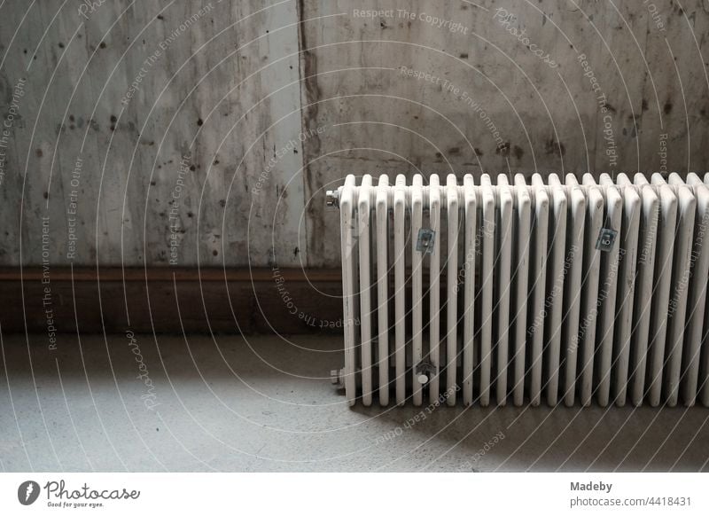 Discarded old radiator in the light of a cellar in a renovated farmhouse in Rudersau near Rottenbuch in the district of Weilheim-Schongau in Upper Bavaria