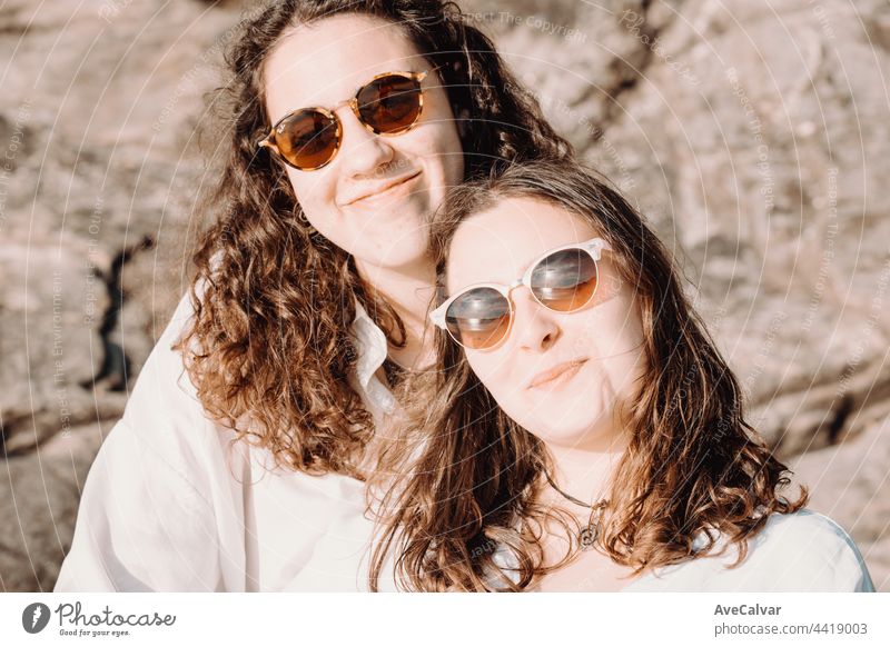 Female friends having fun on day out, on beach and laughing on a summer day. friendship party happiness people group joy photo together youth sand sunglasses at