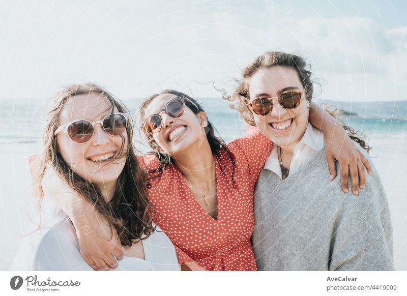 Happy young women laughing and smiling at the beach on a summer day, enjoying vacation, concept of friendship enjoying the outdoor party happiness people group