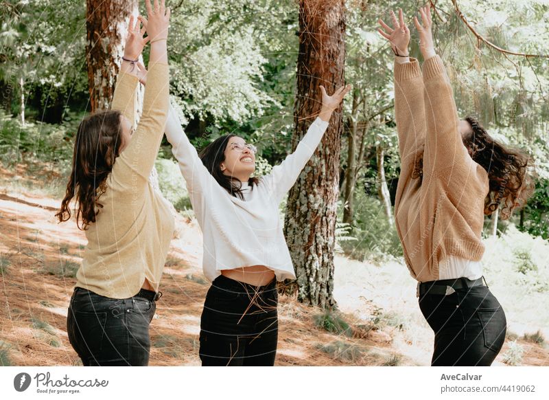 3 young woman having fun playing together in the forest, young students celebrating graduation and notes nature friendship walking adult bonding carefree