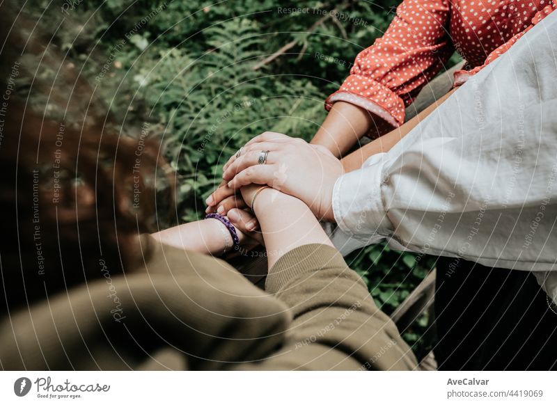 A group of friends holding hands with friendship meaning, support, care and affection concepts, multicultural togetherness happiness agreement meeting
