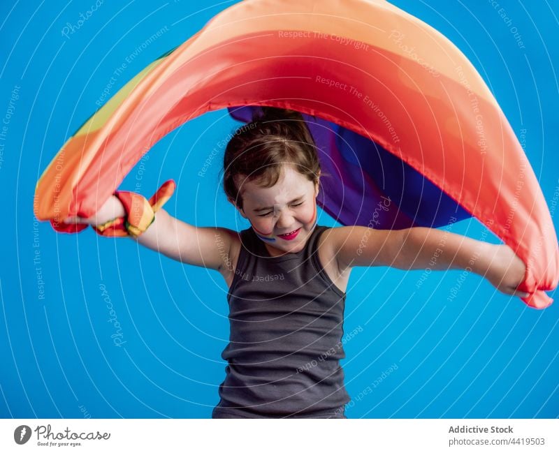 Little girl with closed eyes raising colorful flag above head kid child childhood vivid symbol cute little vibrant eyes closed multicolored innocent adorable