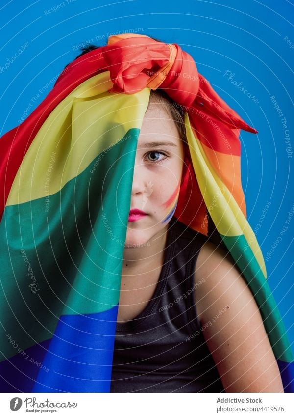 Female child with rainbow flag covering face portrait girl kid colorful human face vivid bright concept symbol cute creative vibrant adorable stripe sign