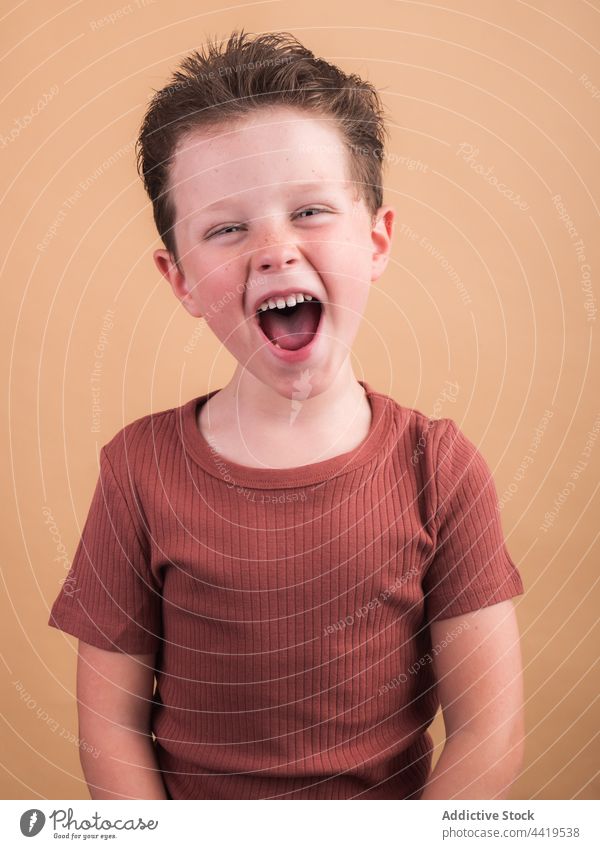 Smiling boy in t shirt on beige background satisfied smile friendly sincere enjoy pleasant kind charming portrait childhood gentle tender cloth cheerful