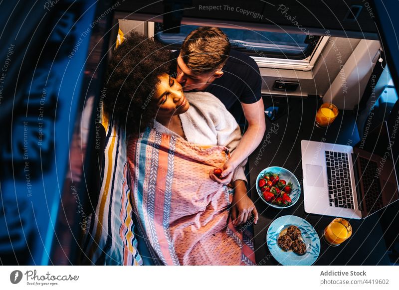 Romantic couple in camper van having meal travel love romantic food together embrace hug relationship young boyfriend girlfriend multiracial multiethnic diverse