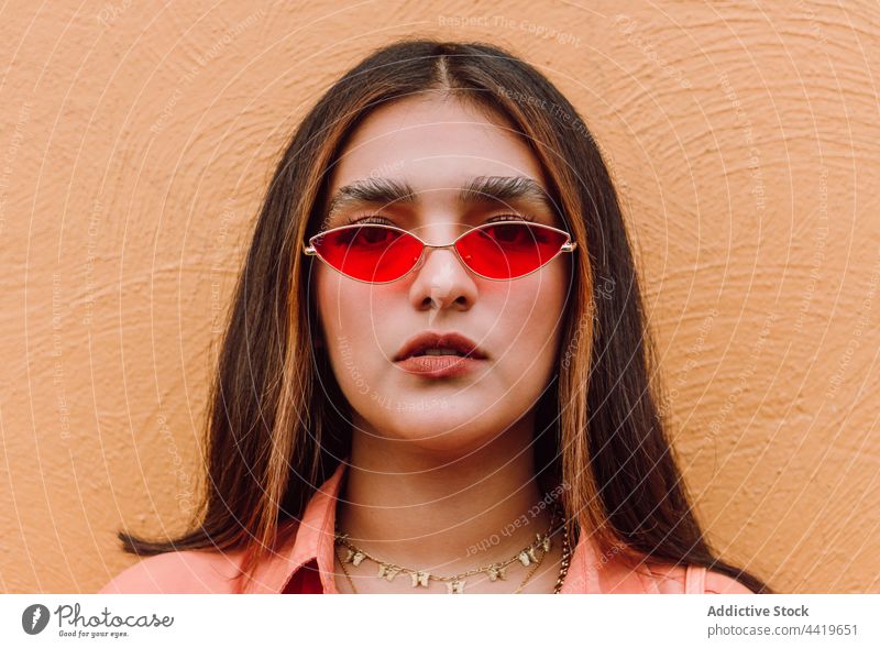 Portrait of woman with stylish sunglasses portrait confident trendy modern style cool looking at camera individuality female long hair brunette feminine