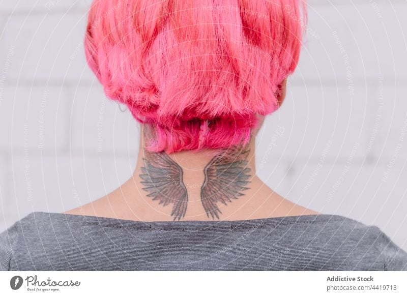 Crop woman with pink hair and tattoo trendy style hairstyle creative urban contemporary unusual neck female wall individuality personality fashion cool modern