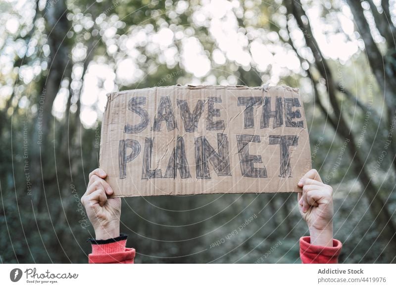 Anonymous girl with Save The Planet inscription on cardboard piece save the planet preserve nature ecology conserve forest portrait trunk tree support female