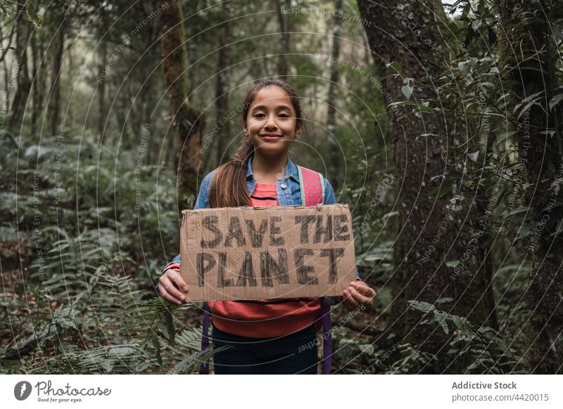 Ethnic girl showing Save The Planet title in summer woods save the planet forest nature environment protect preserve conserve world portrait support smile