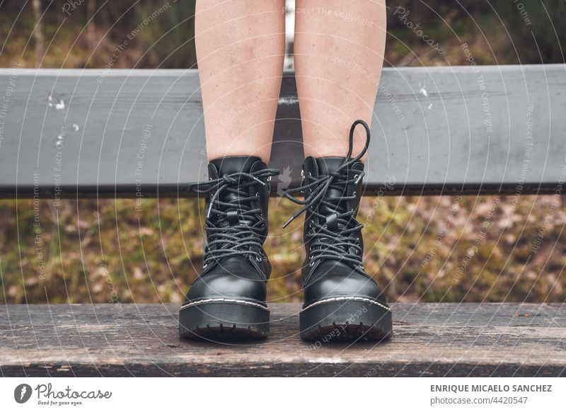 Legs in boots on a park bench person foot horizontal ankle concentration dressed fancy human jump knee learning men messy photograph run sensual sensuality