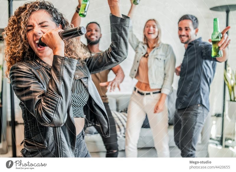 Group of friends playing karaoke at home. group together sing microphone entertainment friendship party lifestyle technology enjoyment happiness drink fun beer
