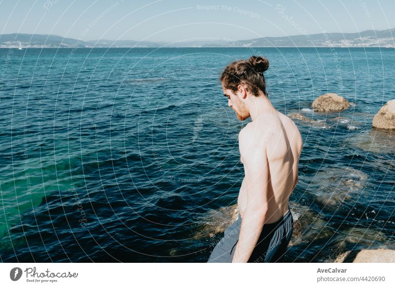 Young man looking the sea, before jumping in, mediterranean holidays, freedom and liberty concepts, modern, pale man horizontal standing tourist one person