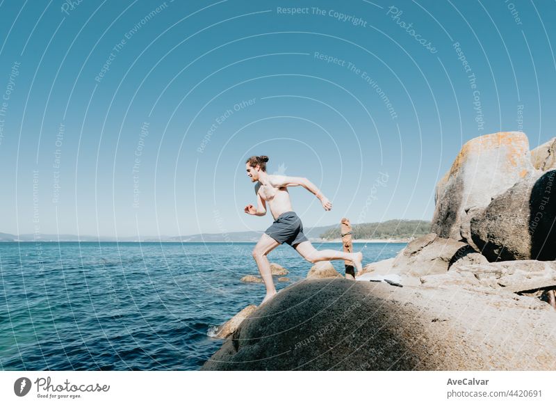 Young man jumping into the sea, running, mediterranean holidays, freedom and liberty concepts, modern, pale man horizontal shirtless young adult carefree