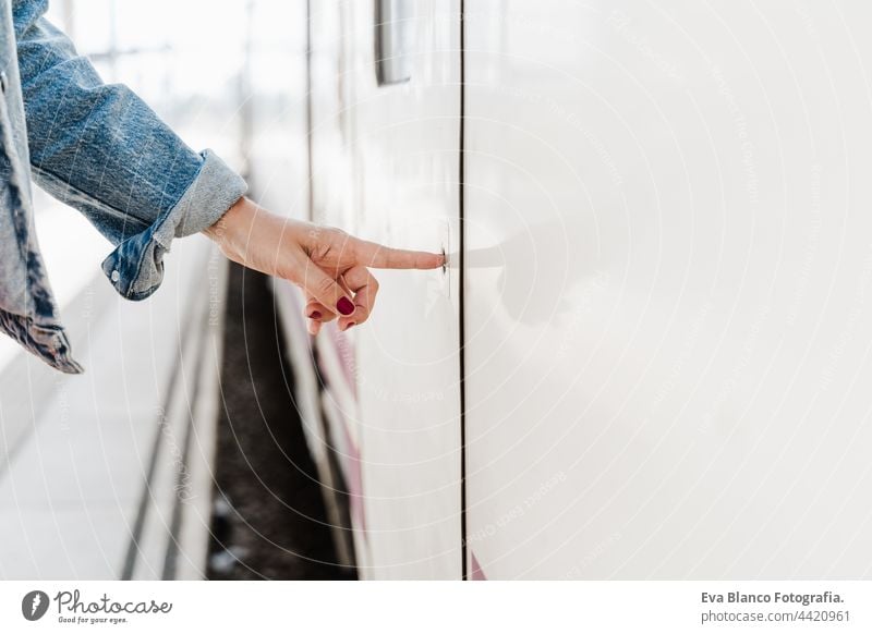 unrecognizable caucasian woman han pressing button on train at railroad station. Travel concept hand open door travel close up wanderlust 30 train station