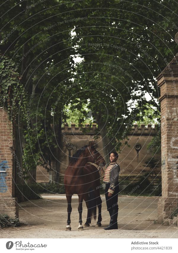 African American woman with horse near building and trees jockey horsewoman castle yard historic fence animal countryside ancestor female black african american