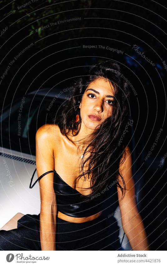 Stylish woman near car at night attractive brunette seductive style glass female young hispanic ethnic long hair blow breath condense reflection bare shoulders