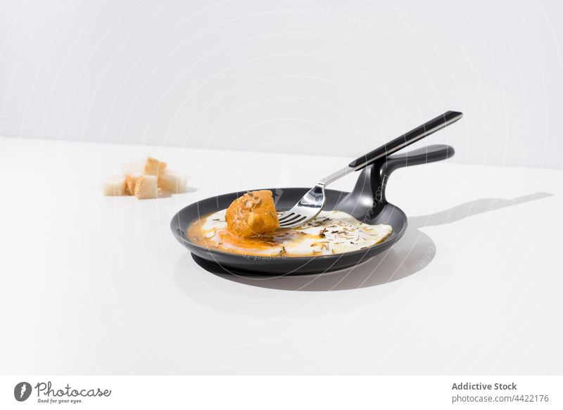 Croutons and fried egg on skillet in white background breakfast serve crouton bread yolk fork piece food dish meal delicious portion tasty cuisine fresh minimal