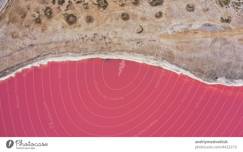 Aerial drone top down photo of a natural pink lake and coast Genichesk, Ukraine. Lake naturally turns pink due to salts and small crustacean Artemia in the water. This miracle is rare.