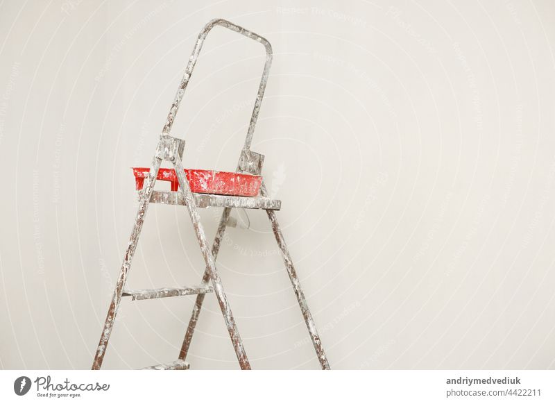 Concept painting work repair painting. metal Ladder, paint cans in a white room for repair. ladder isolated background simple equipment construction silver