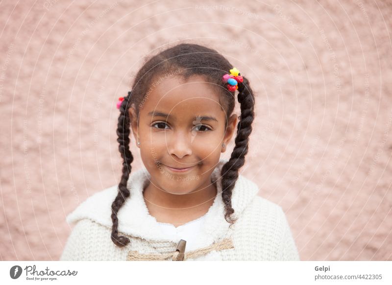 Beautiful african child with a brick a pink wall girl afro black portrait kid smiling childhood young american ethnic outdoors ethnicity pretty little beautiful