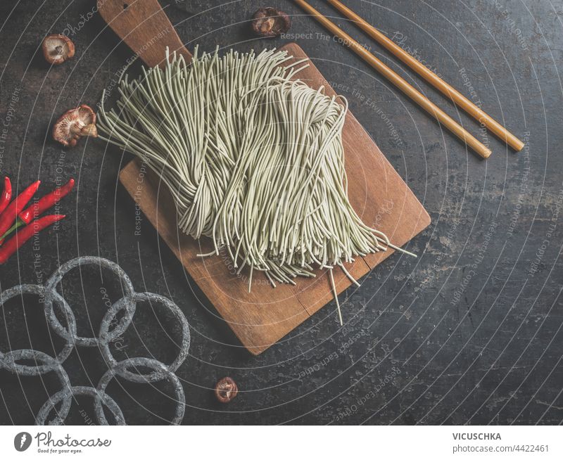 Raw homemade Asian noodles on dark kitchen table with chopsticks. Top view raw asian noodles top view bowl buckwheat buckwheat noodles chinese cuisine
