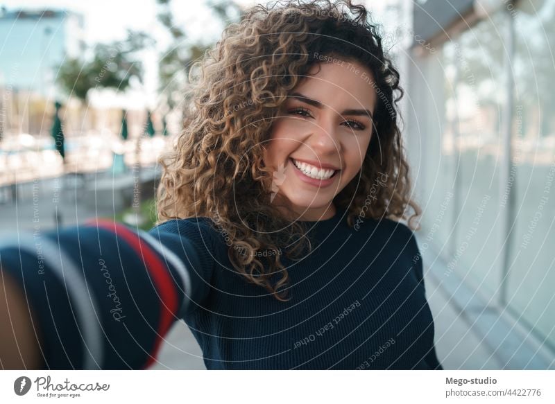 Young woman taking selfies outdoors. young urban city portrait street lifestyle casual female smiling posing one travel confidence take photo outside confident