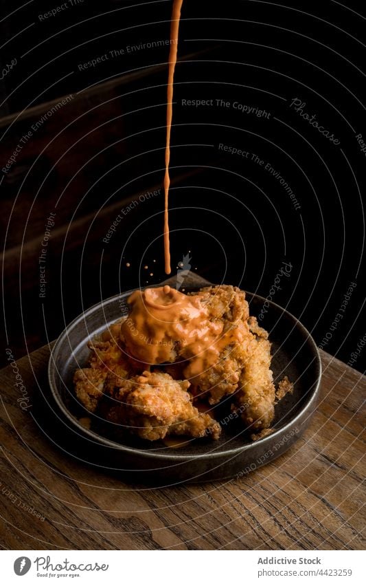 Yummy crispy chicken served with sauce placed on wooden table food dish tasty delicious restaurant plate portion cuisine meal yummy meat fresh gourmet culinary