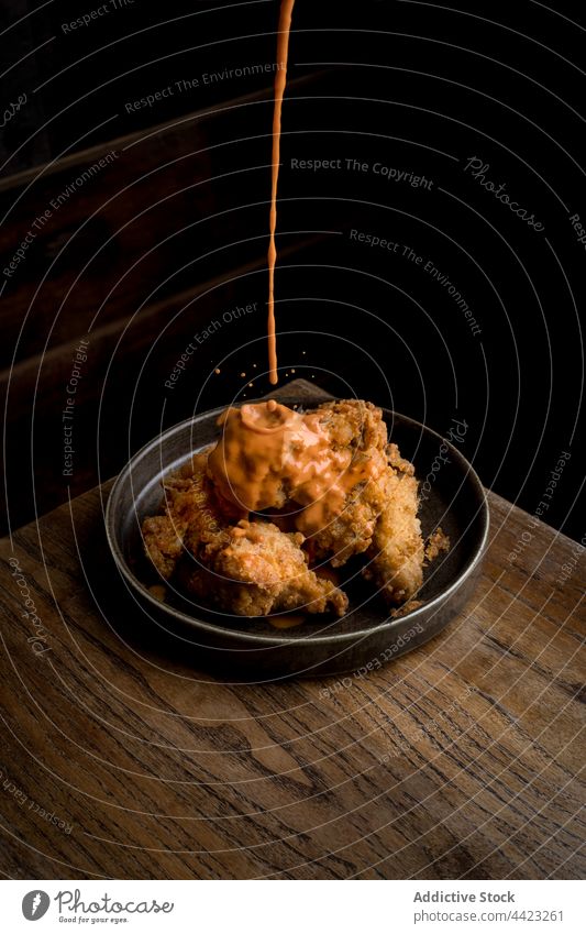 Yummy crispy chicken served with sauce placed on wooden table food dish tasty delicious restaurant plate portion cuisine meal yummy meat fresh gourmet culinary