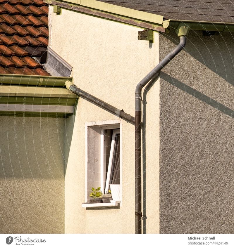 Section of facade with small window, roofs, water pipes and shadows cast House front Wall (building) exterior wall Facade Apartment Building Window Deserted