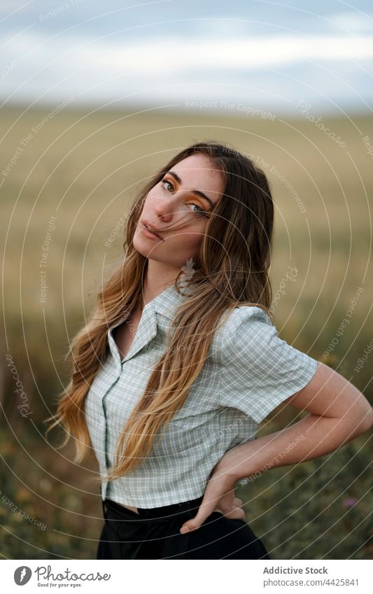Stylish model in field under cloudy sky mindfulness style nature woman countryside dreamy concentrate atmosphere meadow vegetate grow reflective cereal