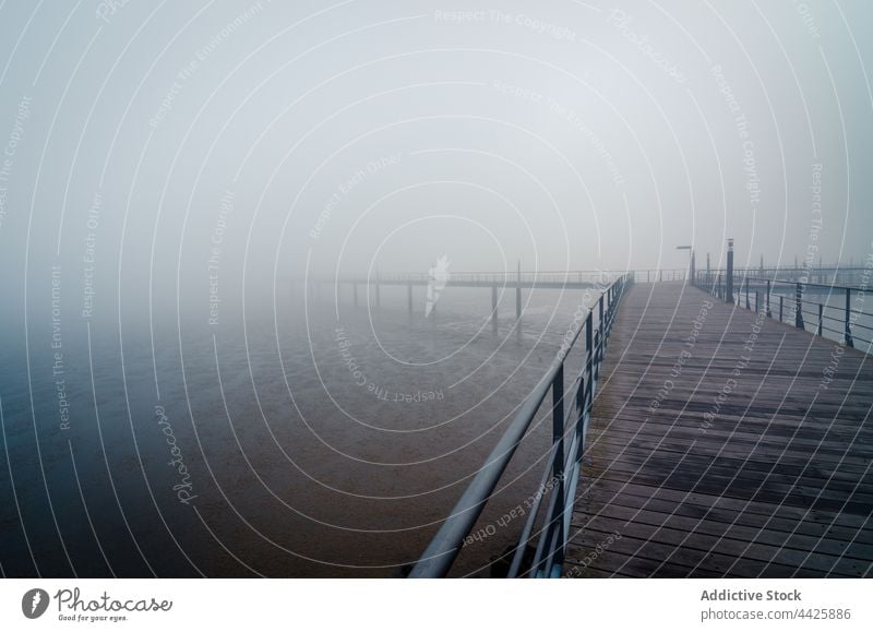 Wooden pier in foggy morning river shore vague weather gray water structure lisbon spain tagus river coast lumber timber wooden mist quay haze calm tranquil