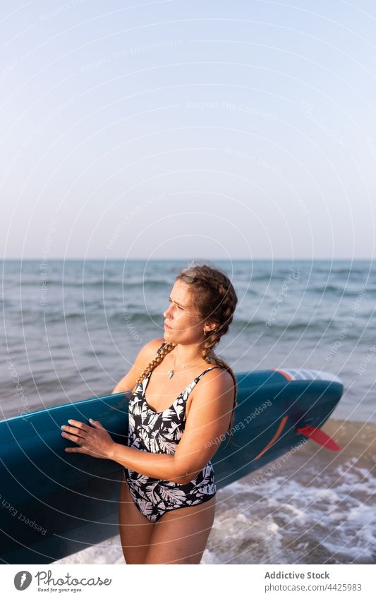 Woman with paddleboard near sea woman sup board surfer summer swimsuit surfboard shore female water stand vacation ocean swimwear enjoy beach holiday aqua