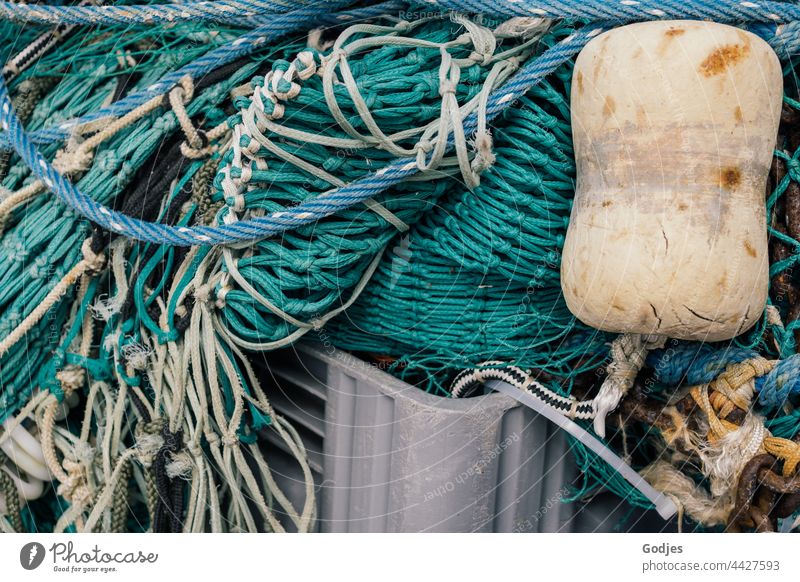 Fishing net lies folded in a box | order in chaos fishing Buoy Net Crate plastic Rope Exterior shot Colour photo Fishery Deserted Knot Structures and shapes