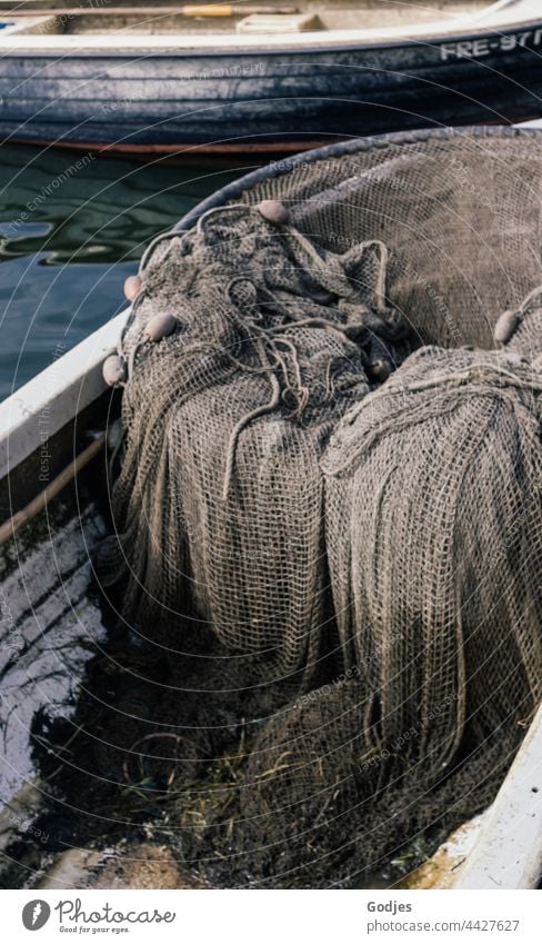https://www.photocase.com/photos/4427627-an-old-fishing-net-lies-in-a-small-fishing-boat-photocase-stock-photo-large.jpeg