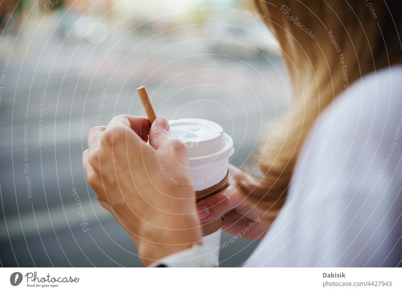 Woman holds paper coffee cup at city street hand woman lifestyle go away outdoor female urban drink morning beverage girl young outside background takeaway