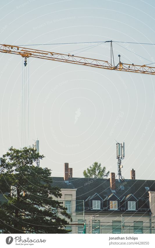 Residential house with transmission mast on the roof and crane Apartment Building Broadcasting tower Roof Crane Pole Antenna Mobile phone mast Radiation Waves