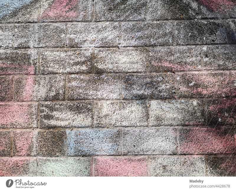 Bunch of chalk colours of a painting by children on rectangular paving stones in summer sunshine in Oerlinghausen near Bielefeld in the Teutoburg Forest in East Westphalia-Lippe