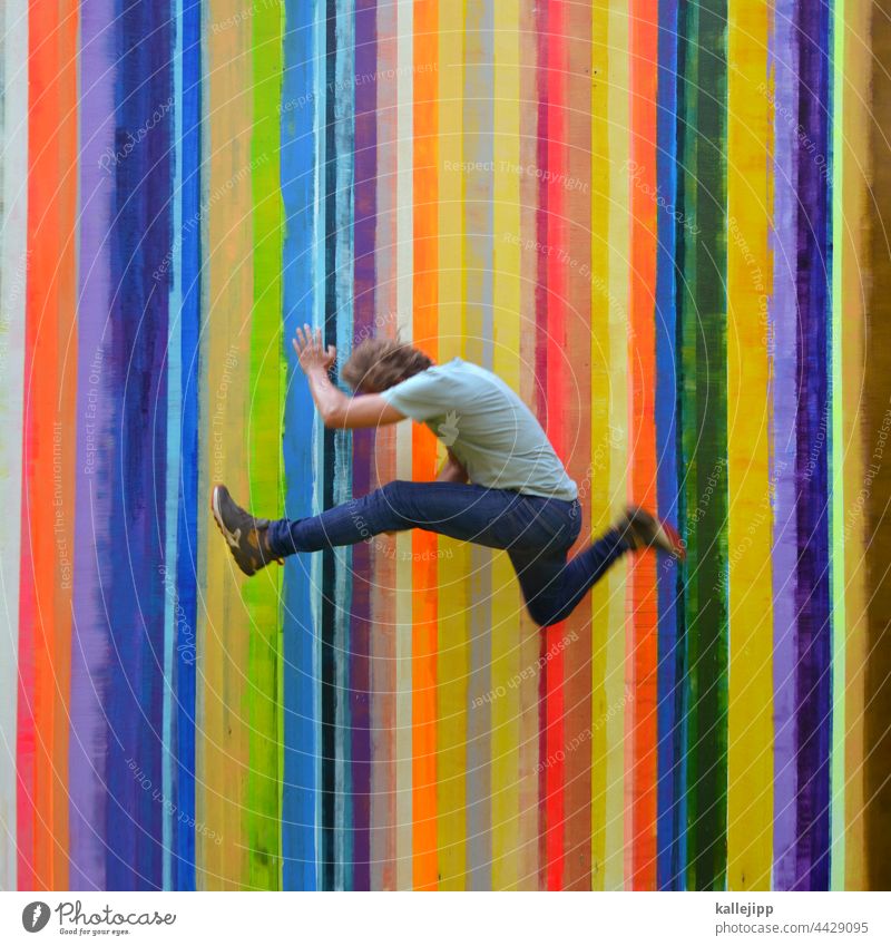 Colourful color strip Colour photo Jump Man Human being Hop colourful variegated Rainbow Stripe Athletic Sports Joy Exterior shot Youth (Young adults) Playing