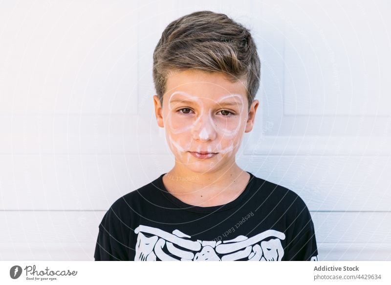Kid with Halloween skeleton makeup kid halloween paint facial boy tradition holiday child event spooky scary party masquerade carnival childhood fantasy serious